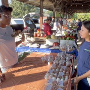 Farm & Agribusiness Management Extension Agent Roshell Rosales Aguilar visits with the Chaidez family during the Athens Farmers Market.